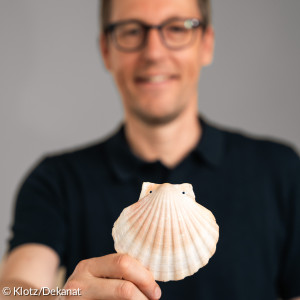 Diakon Marcus Schirmer mit Jacobsmuschel, als Pilgersymbol - sehr passend für den ausgbildeten Pilgerbegleiter. 